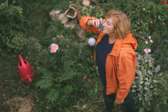 Woman in garden with inhaler