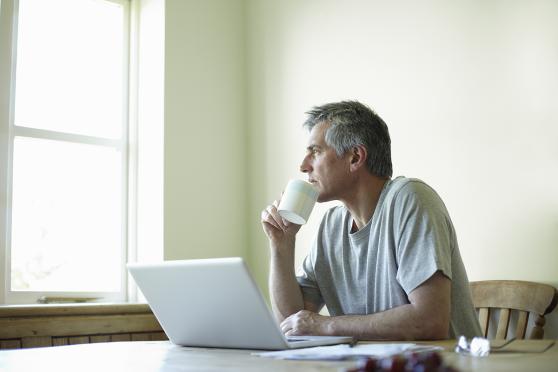 Man with laptop drinking coffee