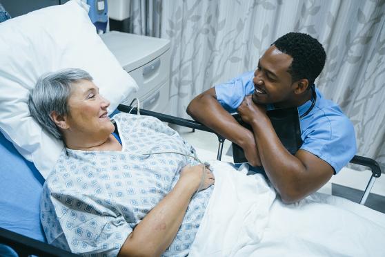 Doctor talking to woman in hospital bed